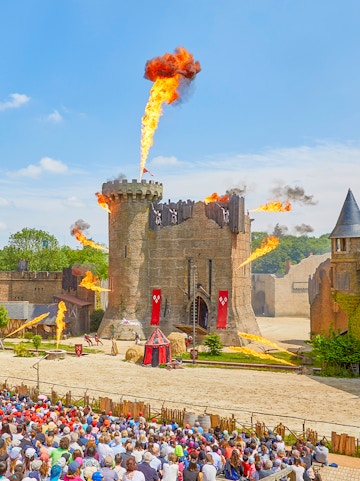 Medieval castle show with fire effects at Puy du Fou, France.
