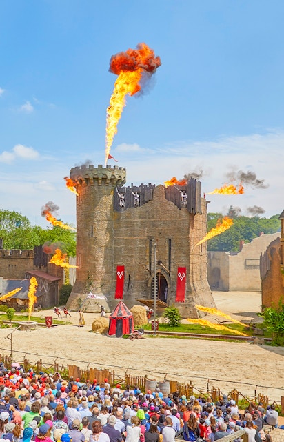 Medieval castle show with fire effects at Puy du Fou, France.