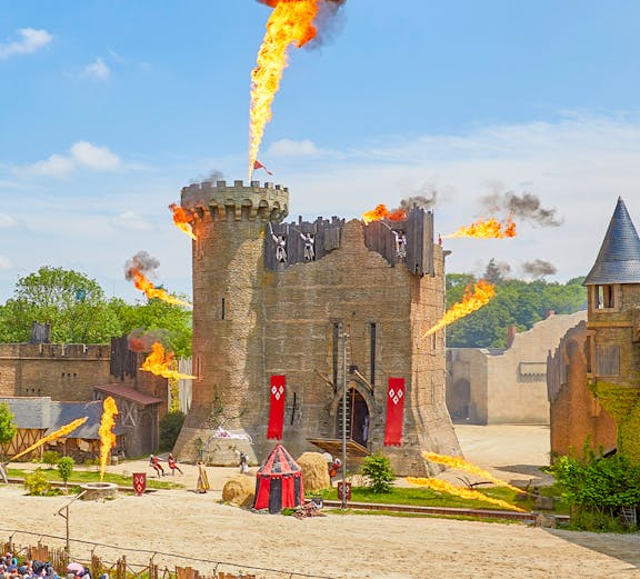 Medieval castle show with fire effects at Puy du Fou, France.