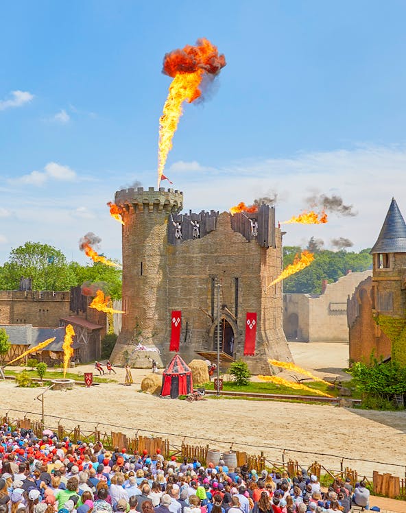 Medieval castle show with fire effects at Puy du Fou, France.