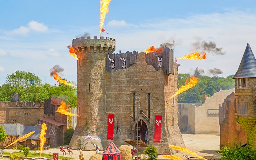 Medieval castle show with fire effects at Puy du Fou, France.