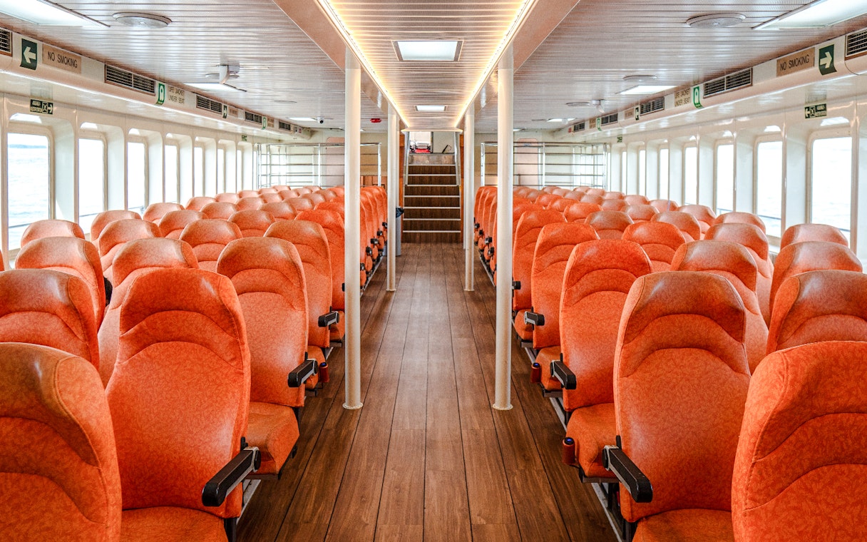 Interior of Singapore to Batam ferry with rows of orange seats.