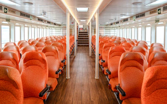 Interior of Singapore to Batam ferry with rows of orange seats.