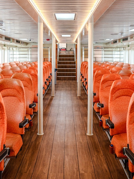 Interior of Singapore to Batam ferry with rows of orange seats.