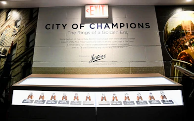 Exhibit of championship rings at The Sports Museum, Boston, showcasing Boston teams' victories.