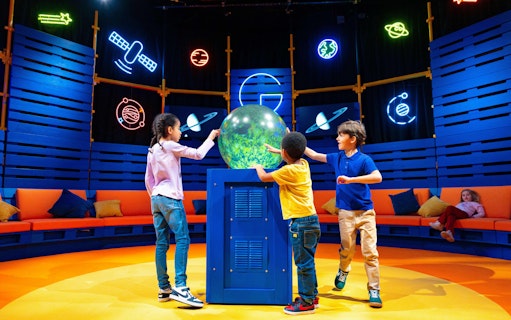Children interacting with a globe at the Astronomers Take Over event, National Maritime Museum.