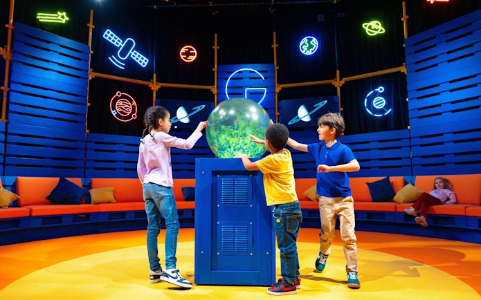 Children interacting with a globe at the Astronomers Take Over event, National Maritime Museum.