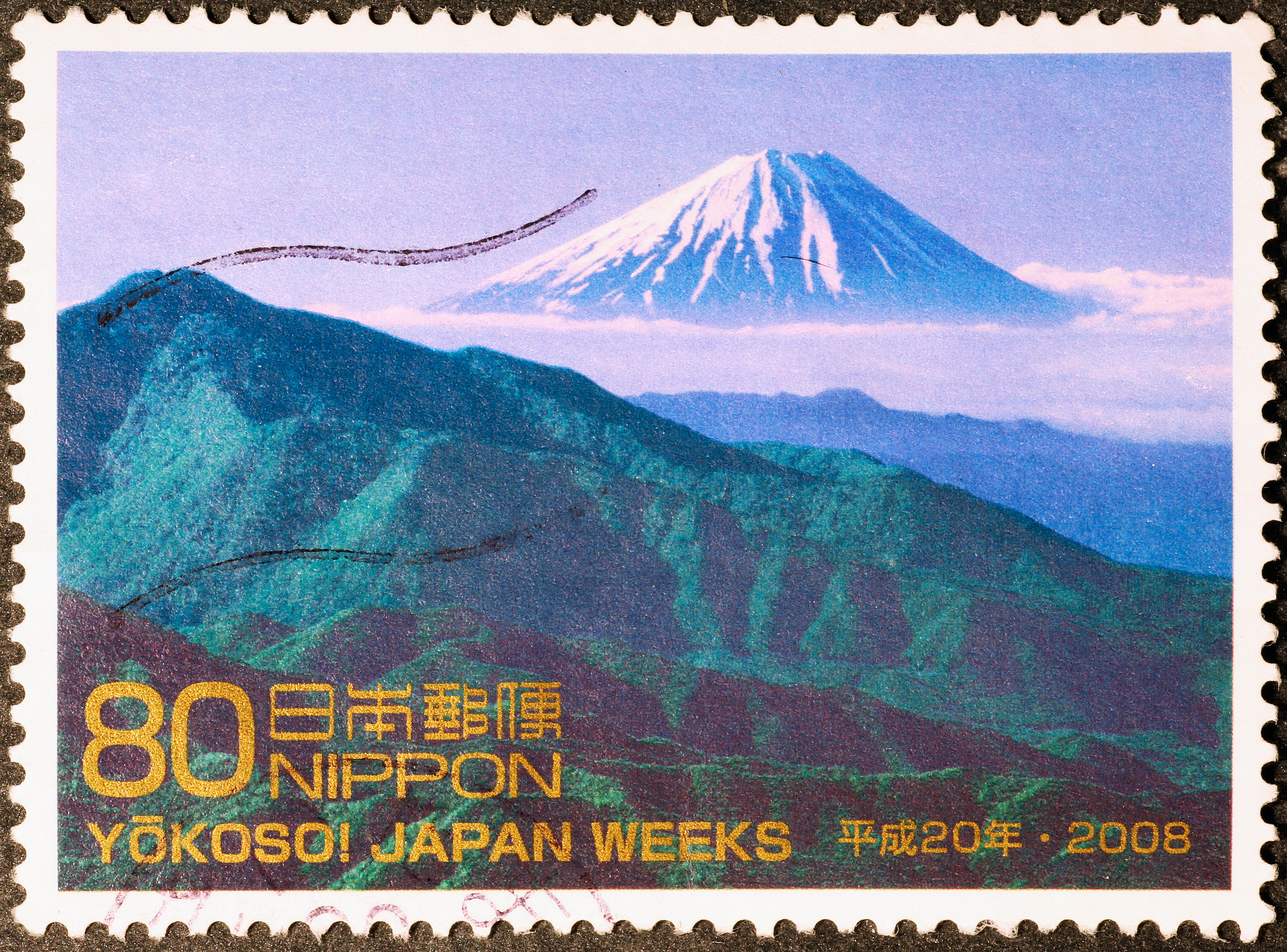 Japanese postage stamp featuring Mount Fuji with green hills.