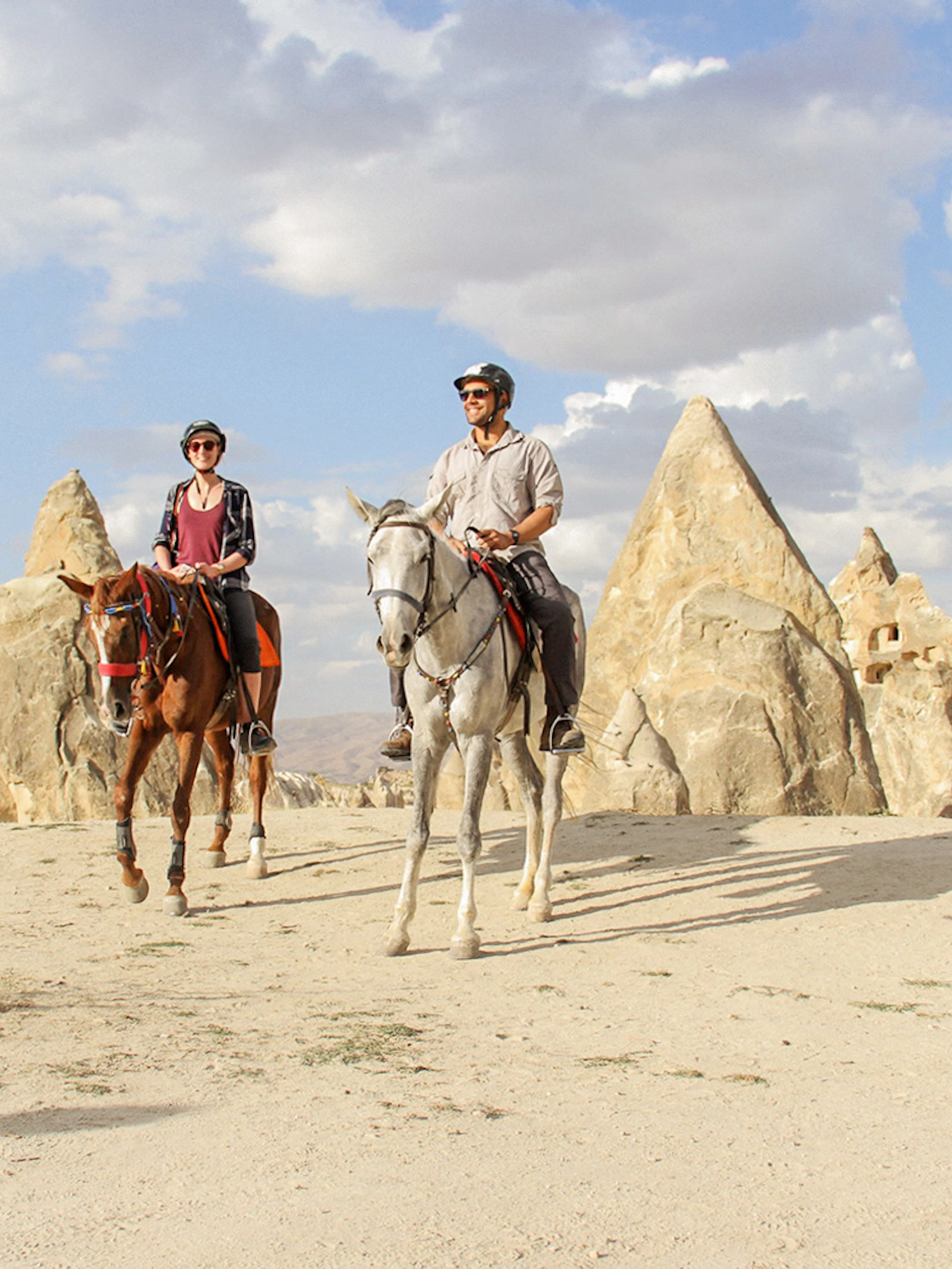 Horseback riders in Cappadocia's unique rock formations during a 2-hour tour.