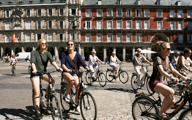 Cyclists enjoying a bike tour in Plaza Mayor, Madrid.