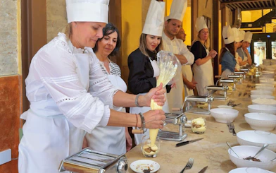 Participants making Tiramisu in a cooking class in Siena.