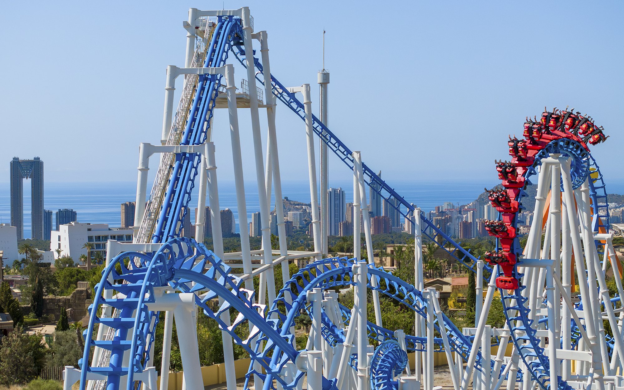 Roller coaster at Terra Mitica Benidorm with city skyline and sea in the background.