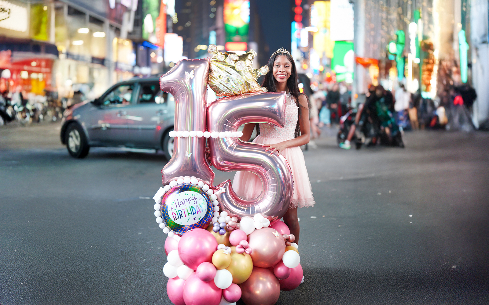 Birthday girl with balloons celebrating sweet 16 in Times Square, NYC.
