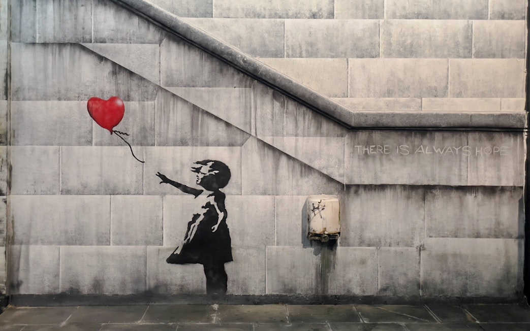 Child reaching for heart-shaped balloon, Banksy artwork, Amsterdam museum.