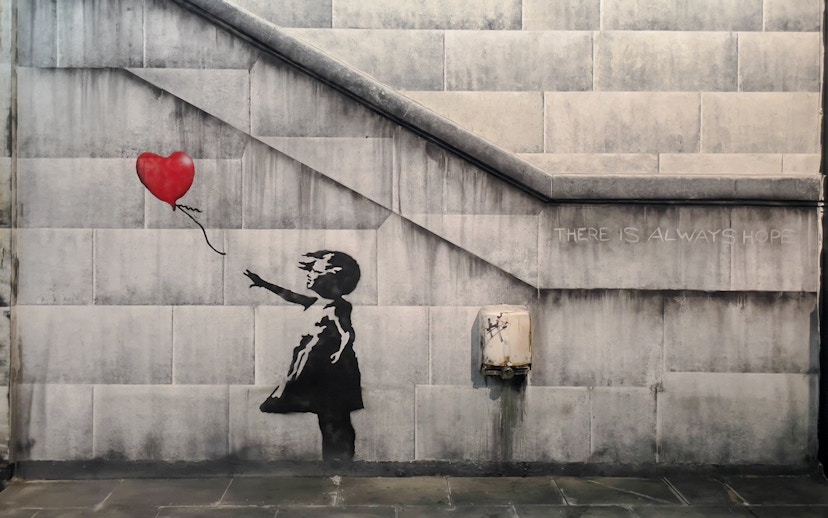 Child reaching for heart-shaped balloon, Banksy artwork, Amsterdam museum.
