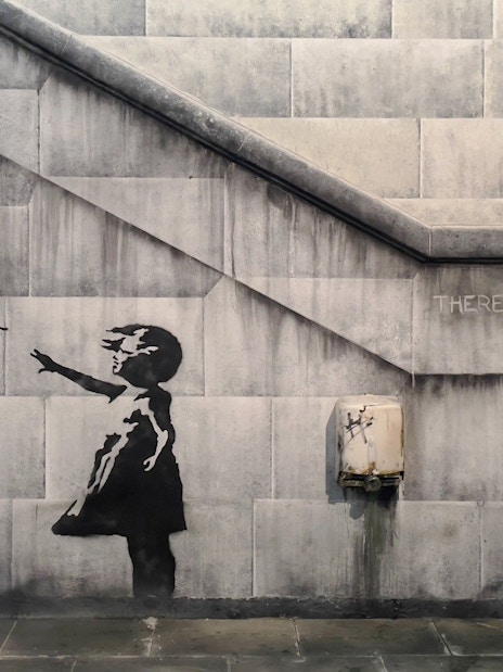 Child reaching for heart-shaped balloon, Banksy artwork, Amsterdam museum.
