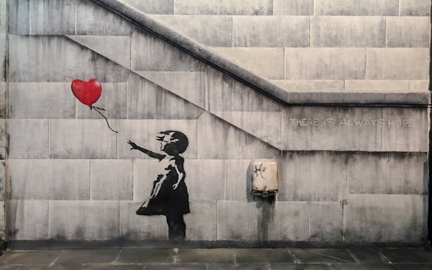 Child reaching for heart-shaped balloon, Banksy artwork, Amsterdam museum.