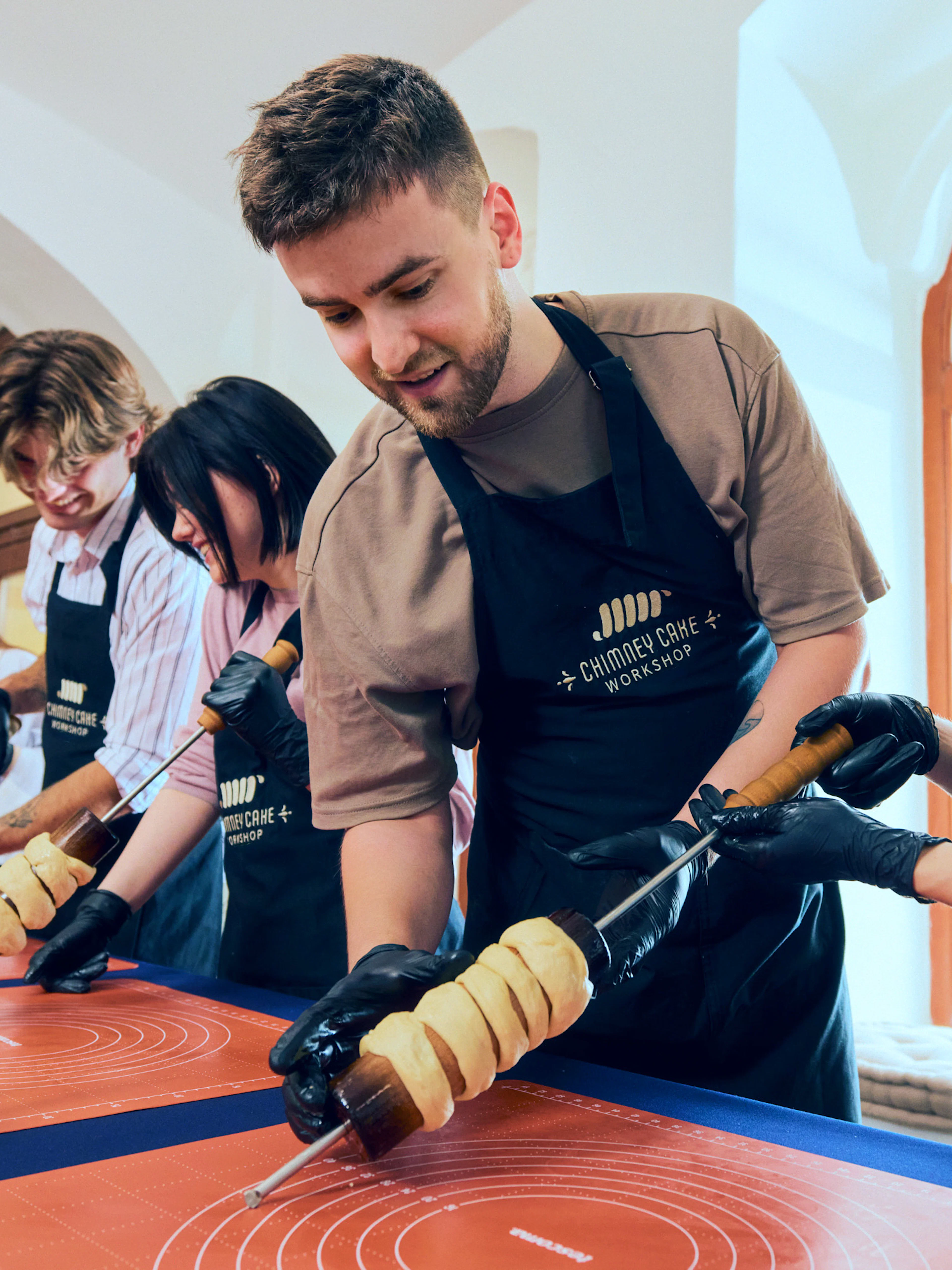 Participants making chimney cakes at a workshop in Budapest.