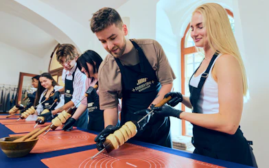 Participants making chimney cakes at a workshop in Budapest.