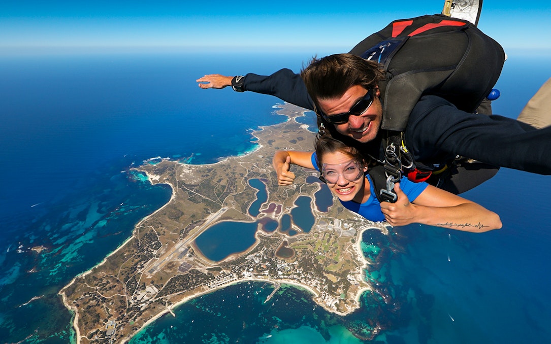 Tandem skydive over Rottnest Island, Perth, with aerial view of coastline and landscape below.