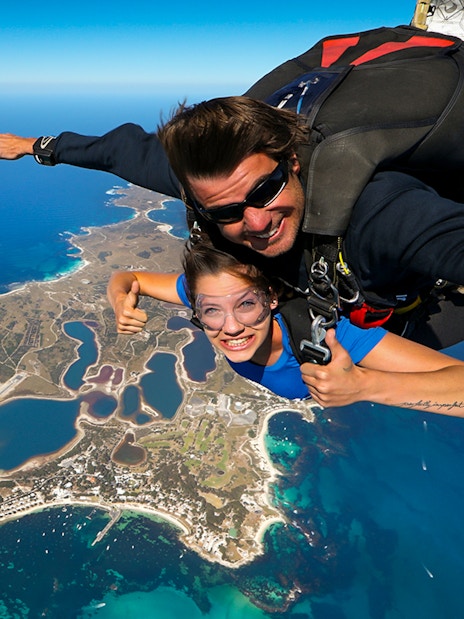 Tandem skydive over Rottnest Island, Perth, with aerial view of coastline and landscape below.