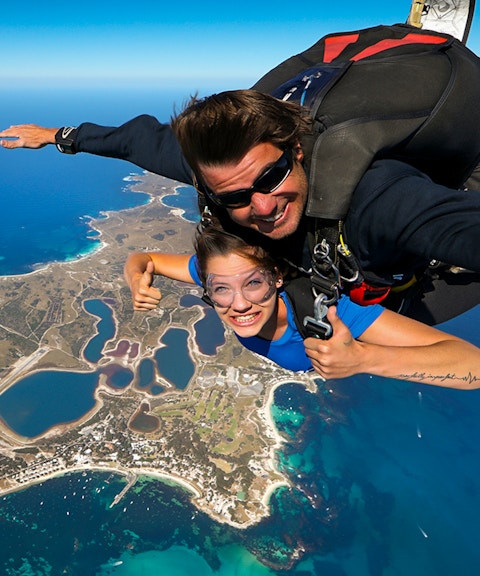 Tandem skydive over Rottnest Island, Perth, with aerial view of coastline and landscape below.
