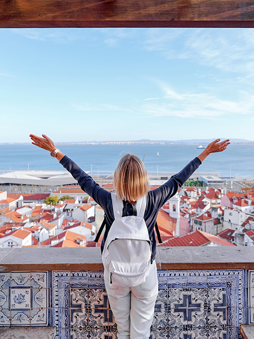 Traveler overlooking Lisbon rooftops and Tagus River on Lisbon to Fatima tour.