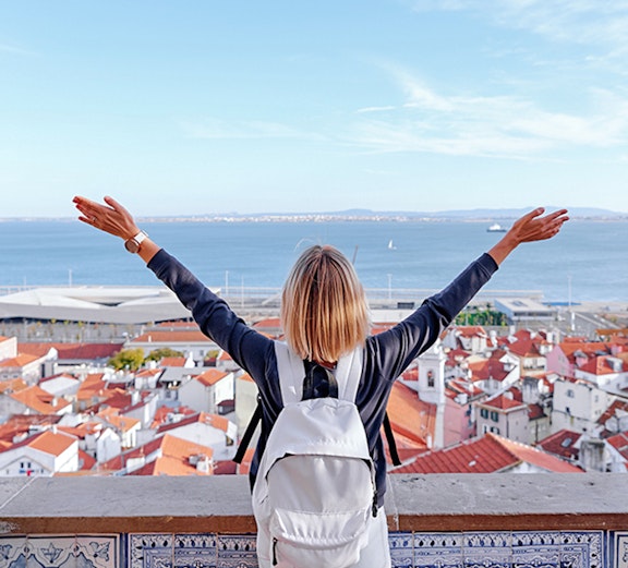 Traveler overlooking Lisbon rooftops and Tagus River on Lisbon to Fatima tour.