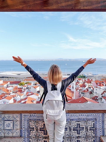 Traveler overlooking Lisbon rooftops and Tagus River on Lisbon to Fatima tour.