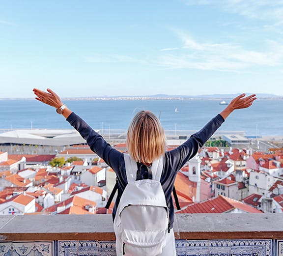 Traveler overlooking Lisbon rooftops and Tagus River on Lisbon to Fatima tour.