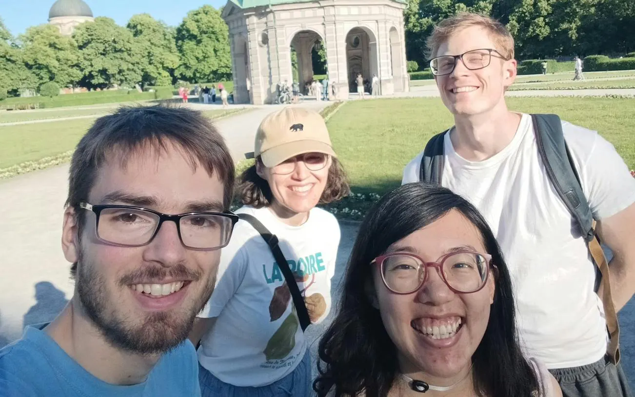 Group of people enjoying the Secret Society in Munich, with a pavilion in the background.