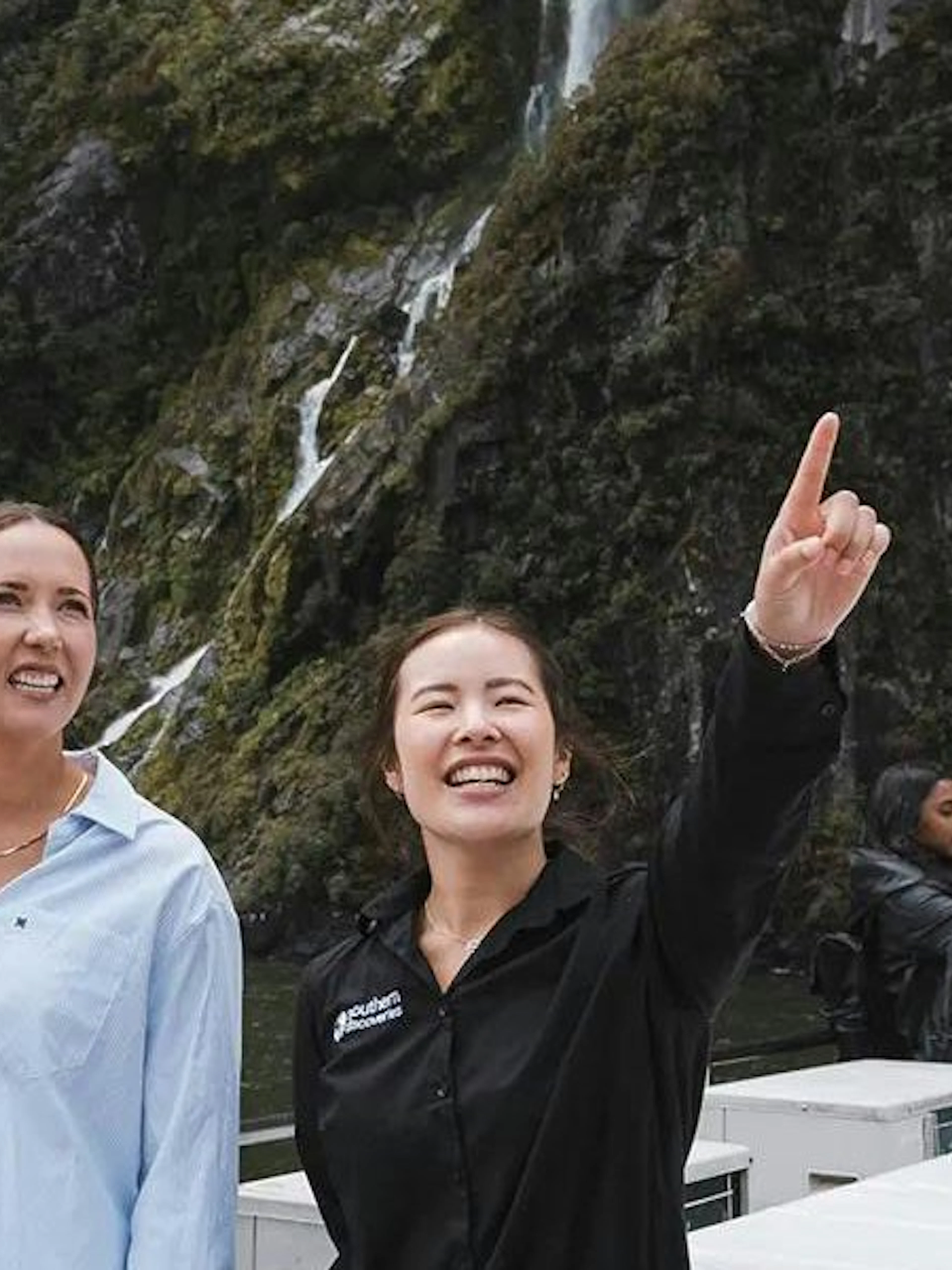 Couple with guide at Milford Sound, enjoying scenic views on VIP cruise from Queenstown.