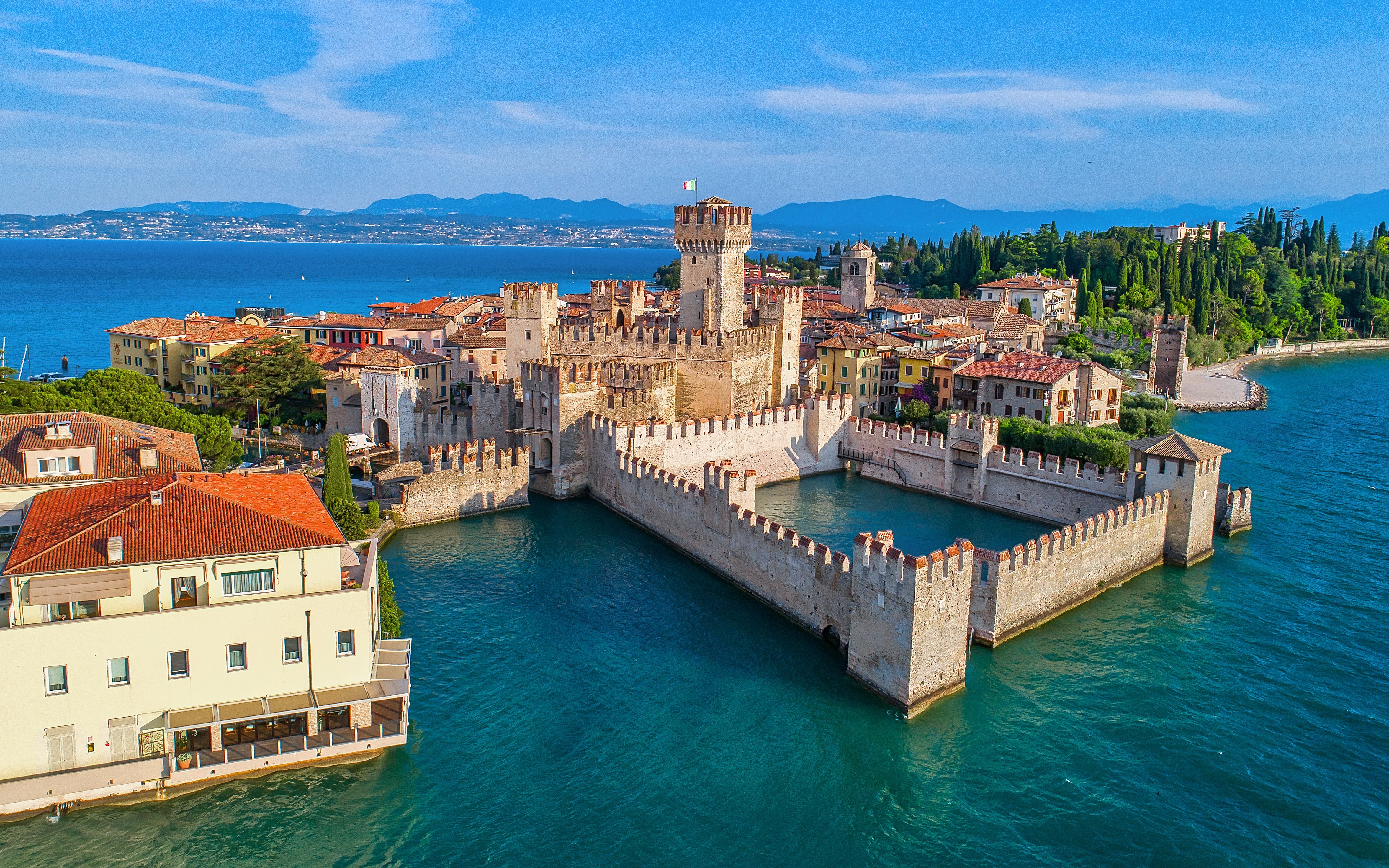 Aerial view of Scaliger Castle surrounded by Lake Garda in Sirmione, Italy.