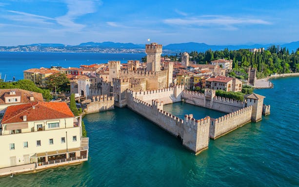 Aerial view of Scaliger Castle surrounded by Lake Garda in Sirmione, Italy.