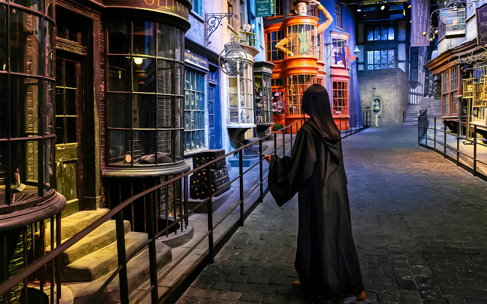 Person in robe with wand on Diagon Alley at Harry Potter London tour.