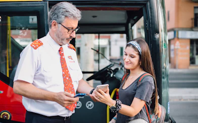 Bus driver assisting tourist with ticket on Thessaloniki Hop-On-Hop-Off Tour.