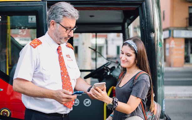 Bus driver assisting tourist with ticket on Thessaloniki Hop-On-Hop-Off Tour.