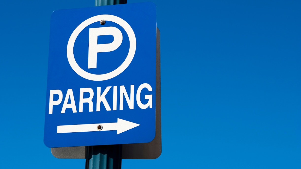 Blue parking sign with arrow pointing right.