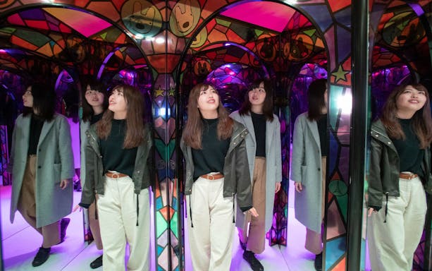Visitors exploring a colorful mirror maze at Fuji Q Highland.