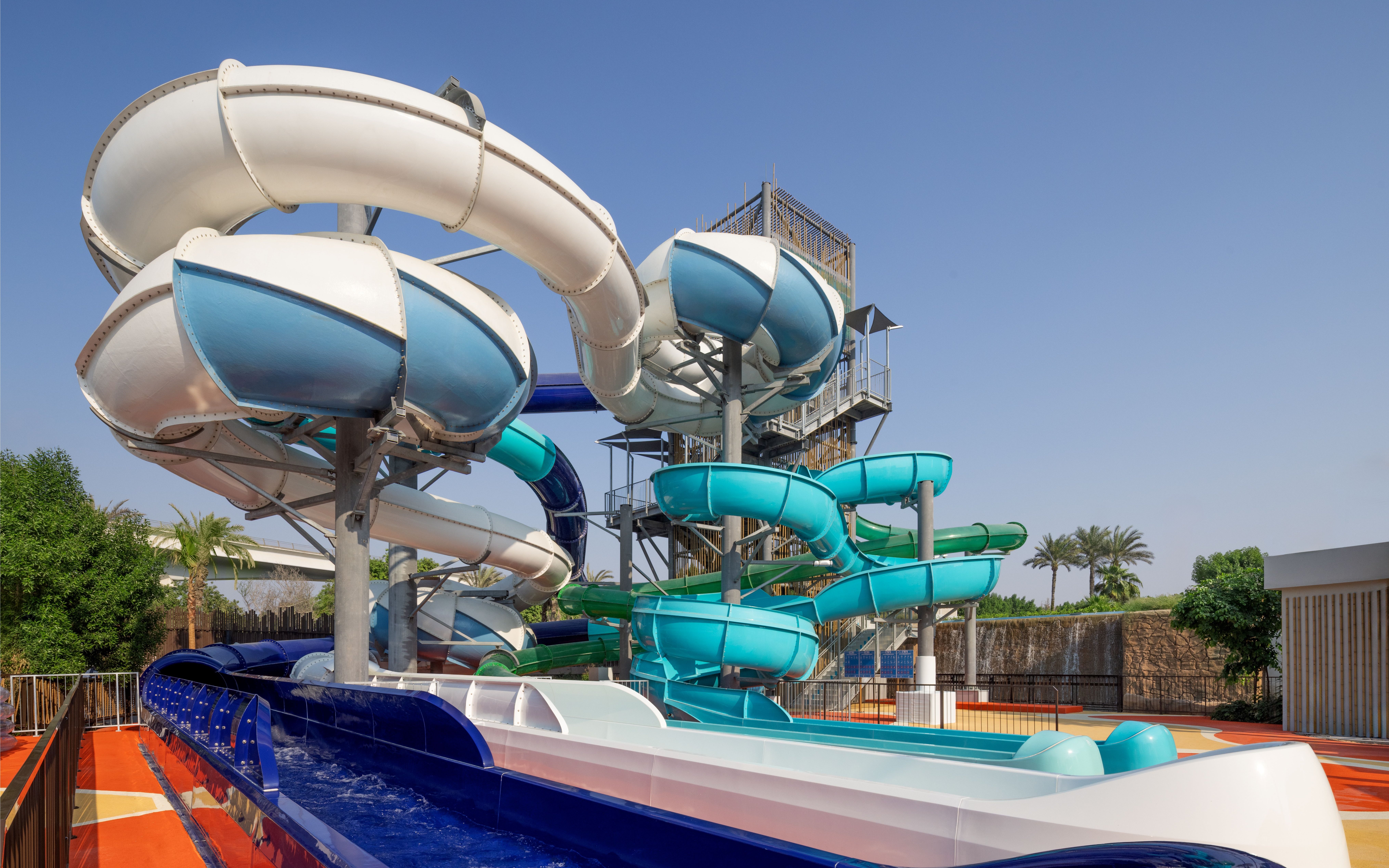 Water slides at Grand Hyatt waterpark, Dubai with palm trees in the background.