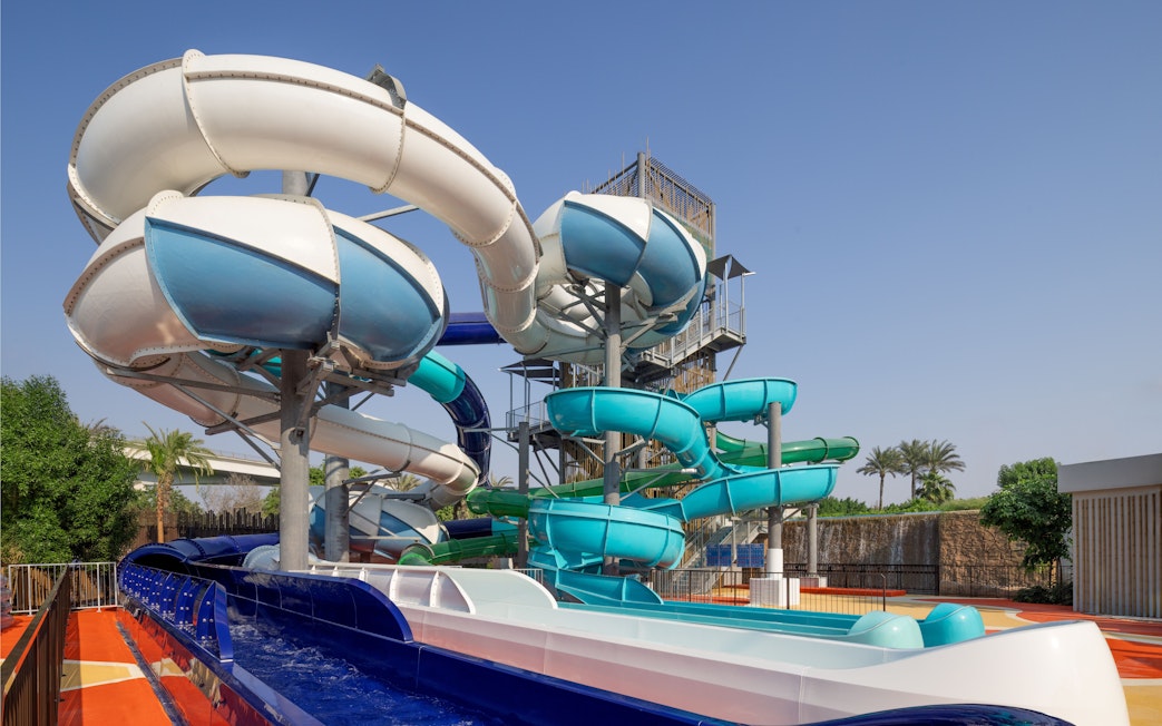 Water slides at Grand Hyatt waterpark, Dubai with palm trees in the background.