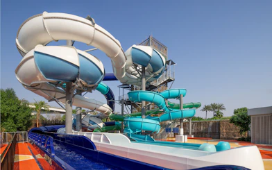 Water slides at Grand Hyatt waterpark, Dubai with palm trees in the background.