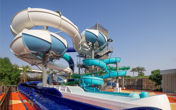 Water slides at Grand Hyatt waterpark, Dubai with palm trees in the background.
