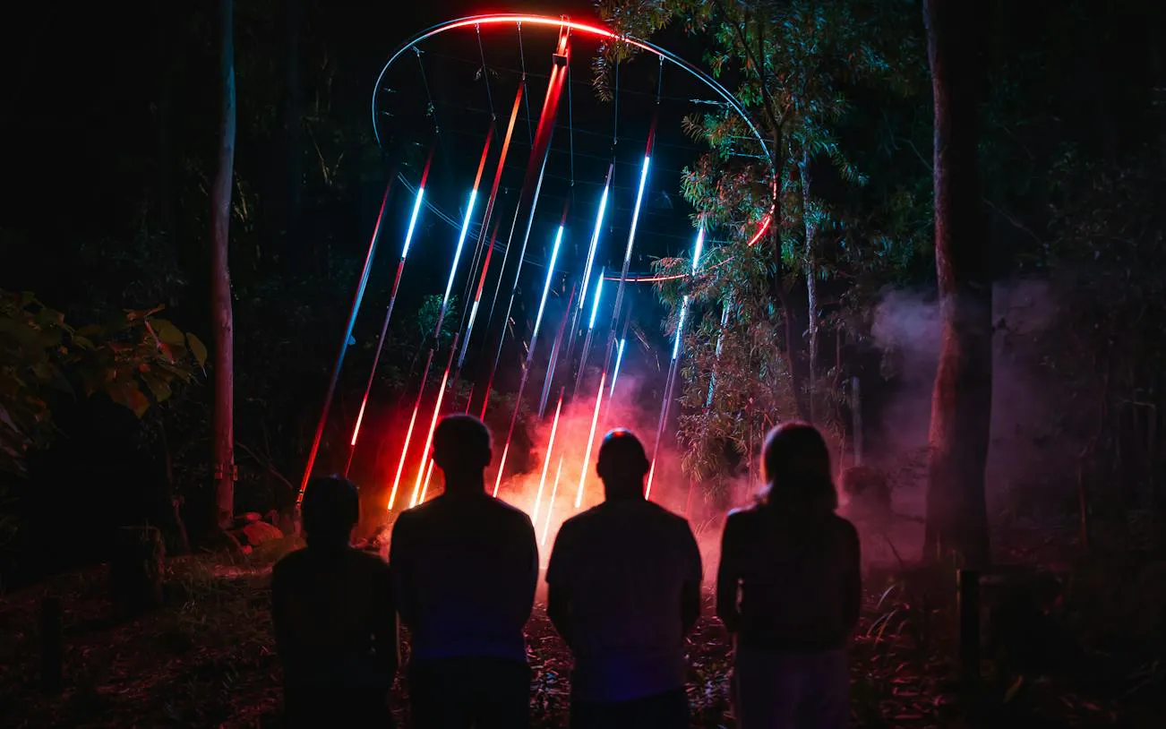 Visitors viewing colorful light installation at Astra Lumina, Currumbin Wildlife Sanctuary, Gold Coast.