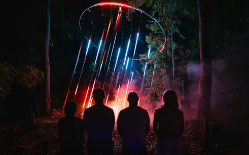 Visitors viewing colorful light installation at Astra Lumina, Currumbin Wildlife Sanctuary, Gold Coast.