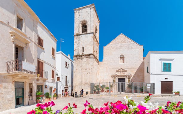 Historic church and buildings in Polignano a Mare during a walking street food tour.