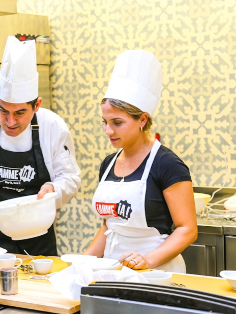 Tourists learning to cook with a chef at Neapolitan Cooking School in Sorrento.