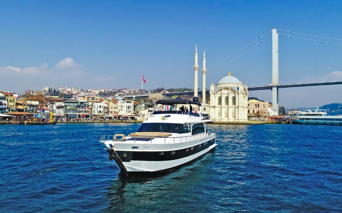 Luxury yacht cruising near Ortaköy Mosque on the Bosphorus, Istanbul.