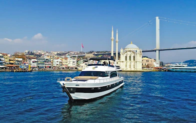 Luxury yacht cruising near Ortaköy Mosque on the Bosphorus, Istanbul.