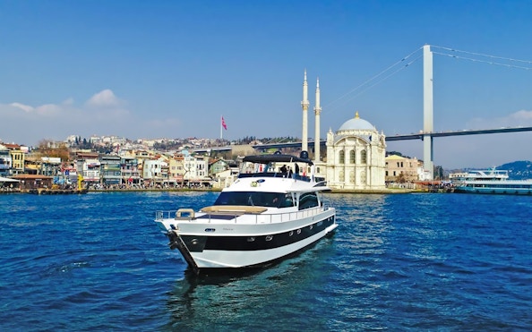 Luxury yacht cruising near Ortaköy Mosque on the Bosphorus, Istanbul.